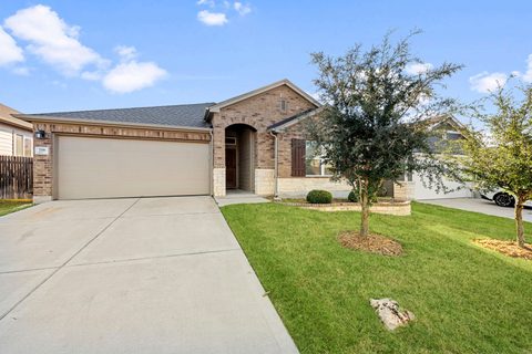Charming Exterior: Enjoy curb appeal with lush greenery and elegant brick details in Buda!
